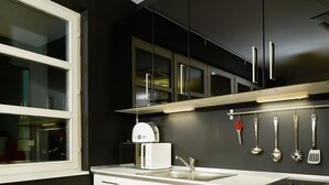 A modern kitchen with white cabinets, a built-in oven, and a stainless steel range hood.