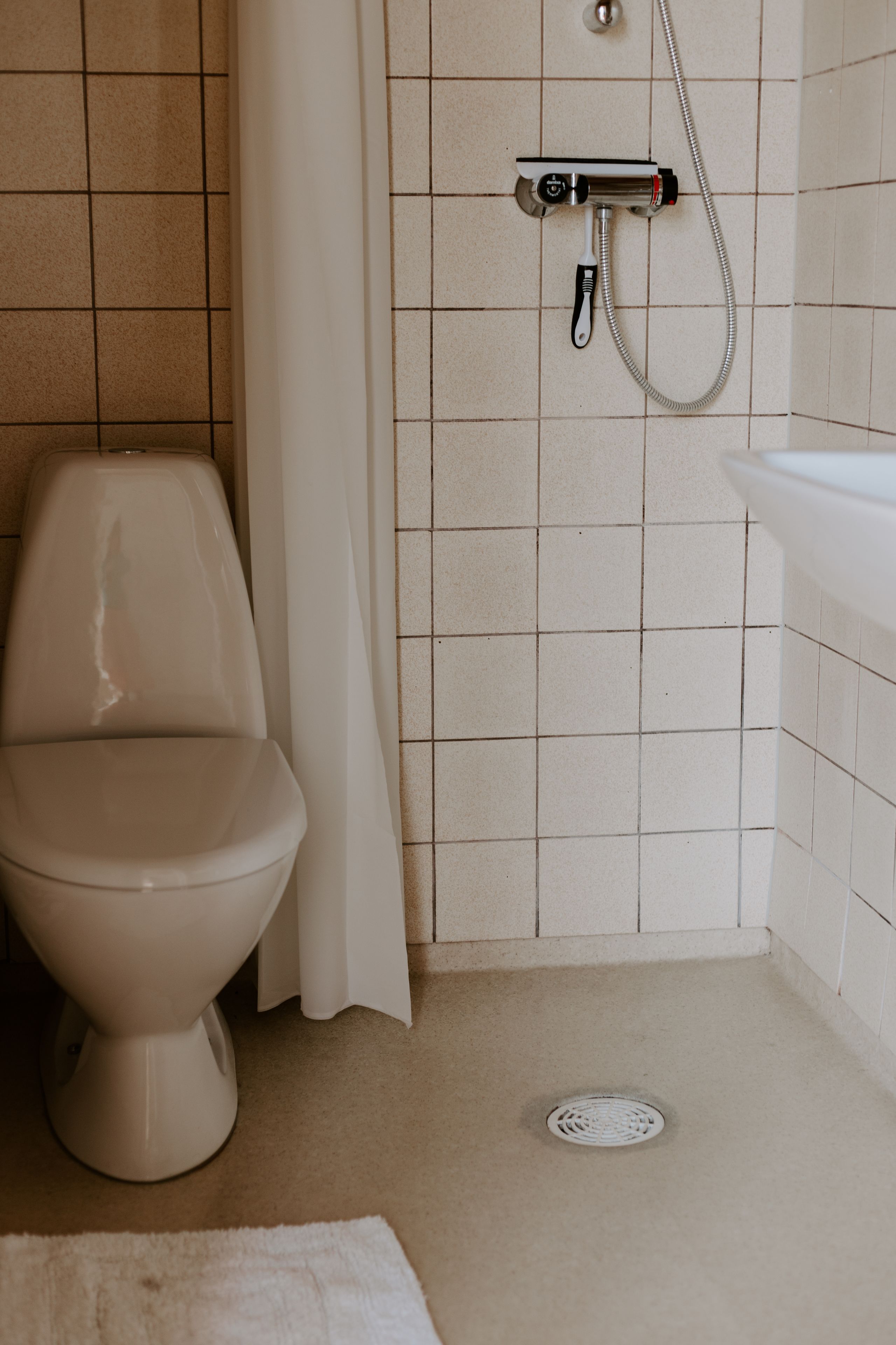 Un baño con inodoro, ducha y lavamanos.