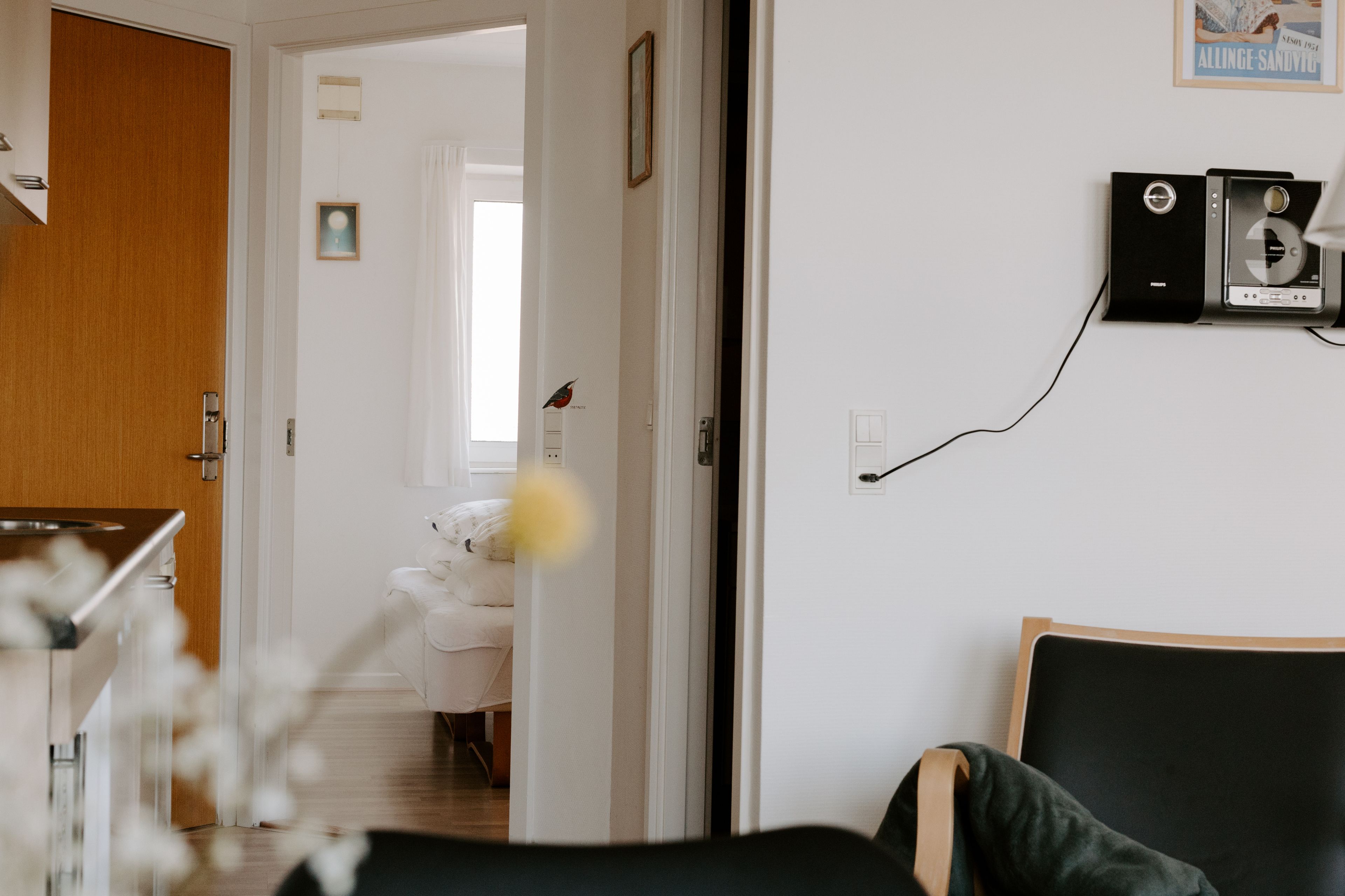Una habitación moderna con cama, escritorio y altavoz en la pared.