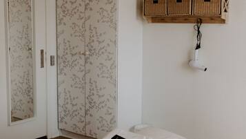 Une chambre à coucher avec un lit, une armoire et une étagère avec des paniers.