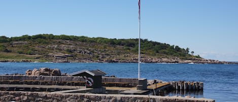 A marina with boats docked, a lifebuoy, and a flagpole.