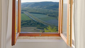 Una ventana con vistas a un paisaje que incluye campos y una carretera.