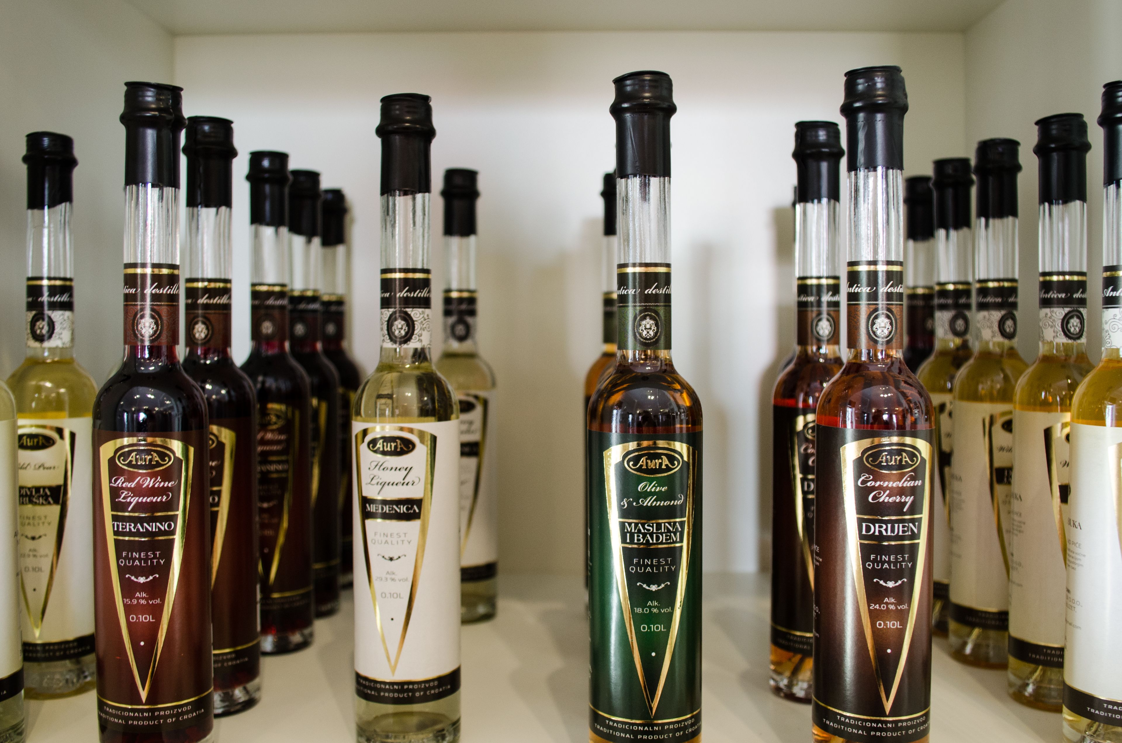 Variedad de botellas de licor dispuestas en una estantería.