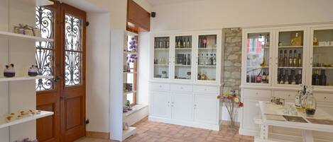 Ein Zimmer mit Holztür, weißen Schränken mit Glastüren und Fliesenboden.