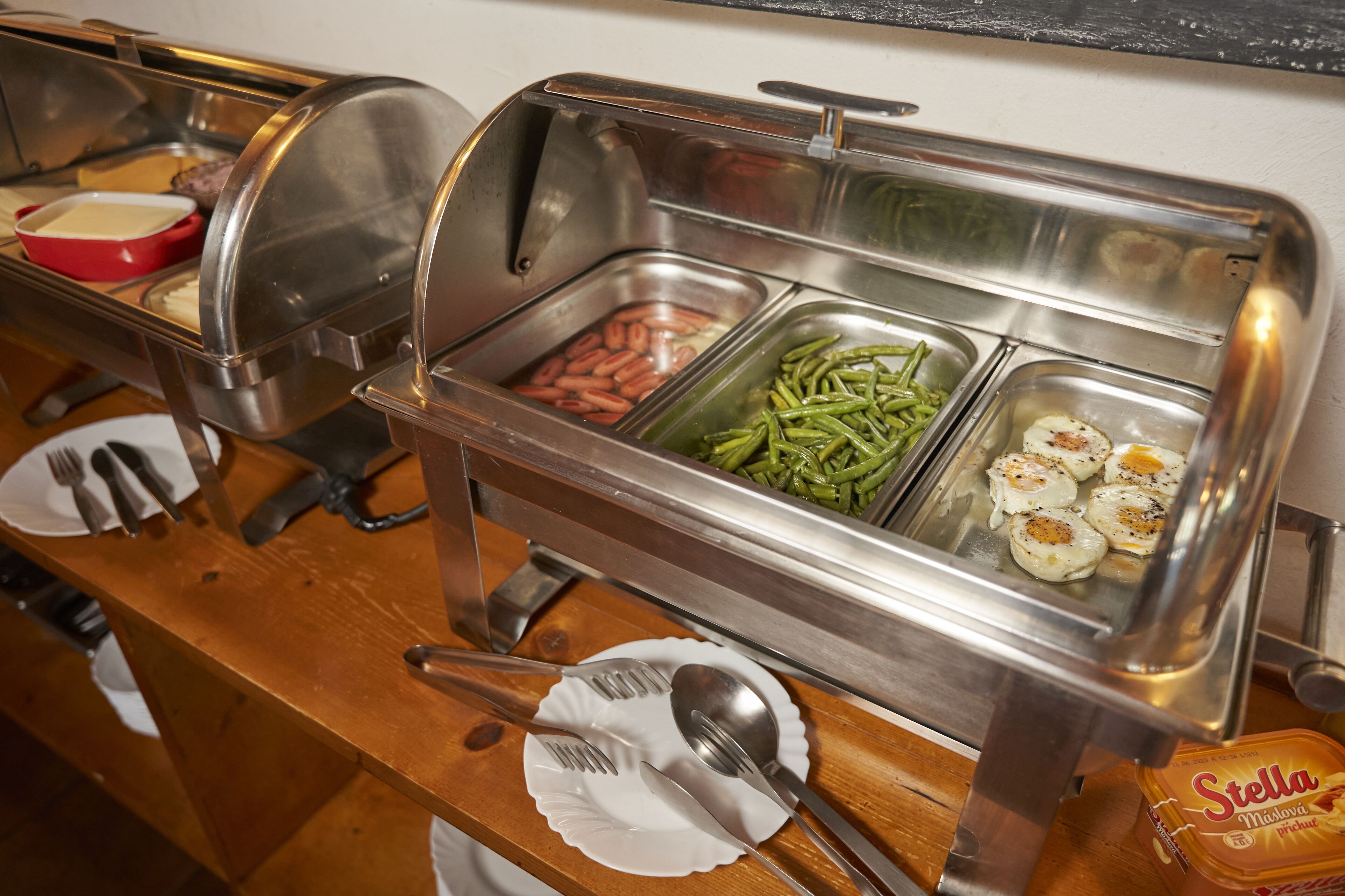 Ein Buffet mit verschiedenen Speisen, darunter Eier, grüne Bohnen und Würstchen.