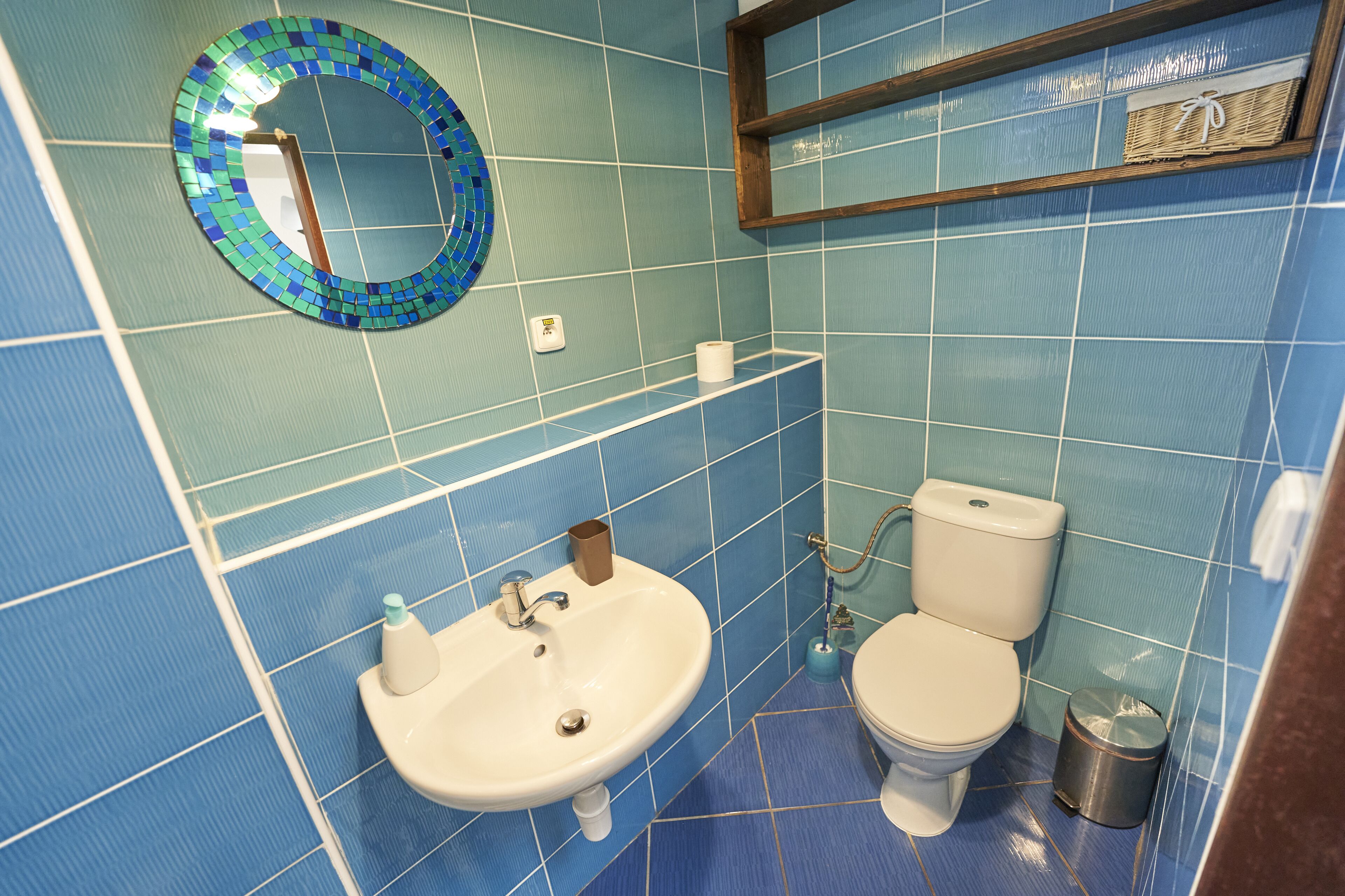 A bathroom with a sink, toilet, and a mirror.