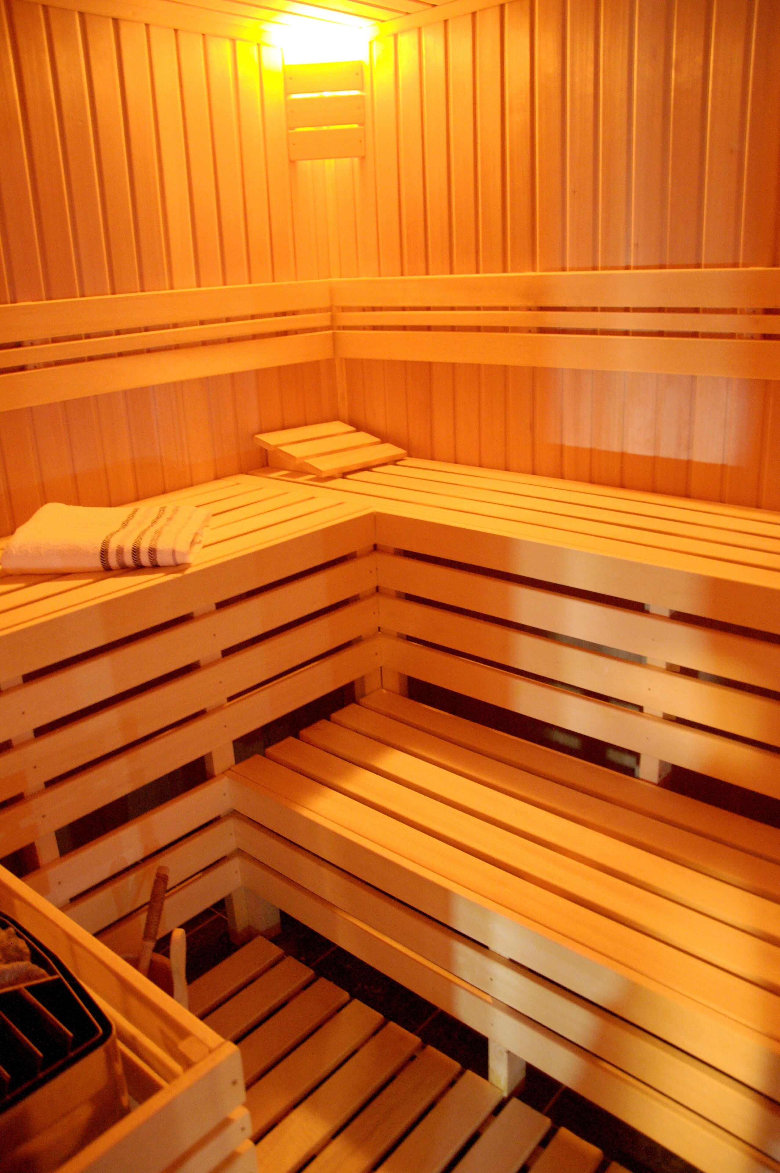A sauna with wooden benches and a bench with a towel.