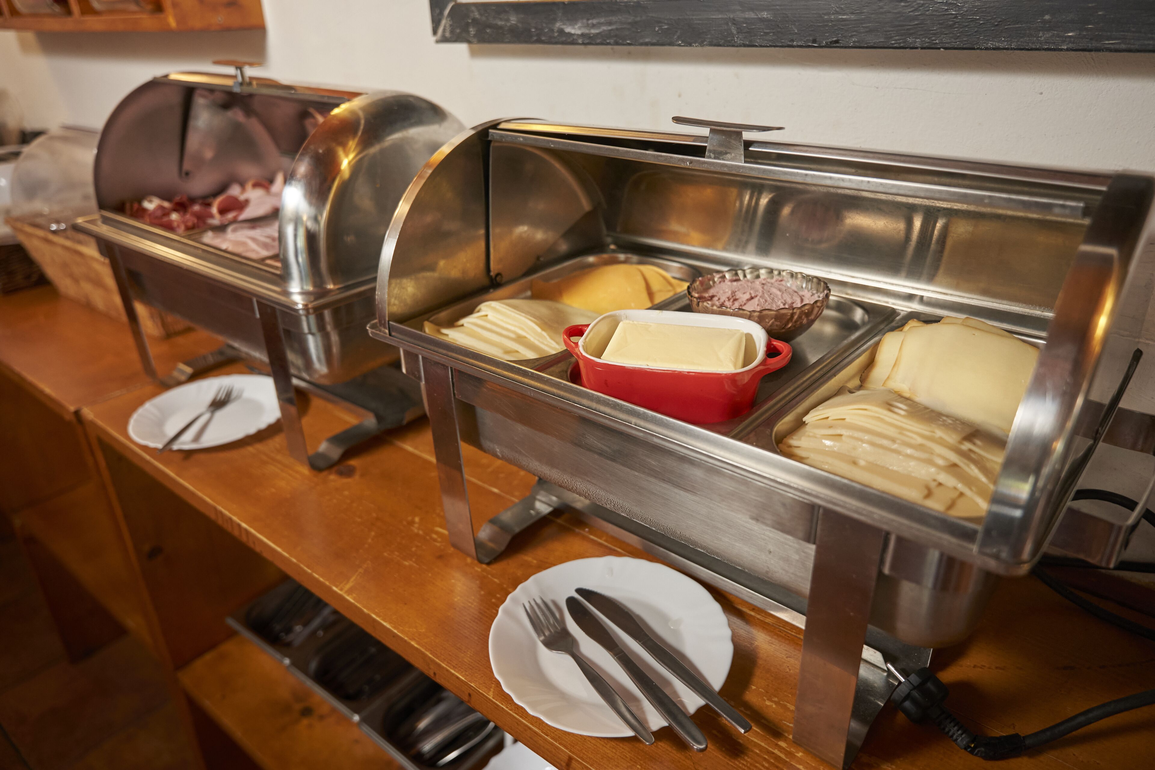 A buffet setup with various food items and utensils.