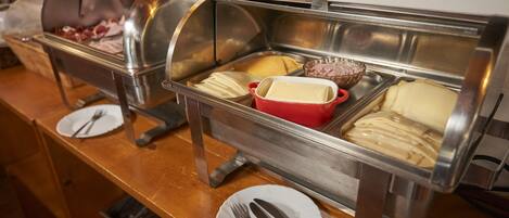 A buffet setup with various food items and utensils.