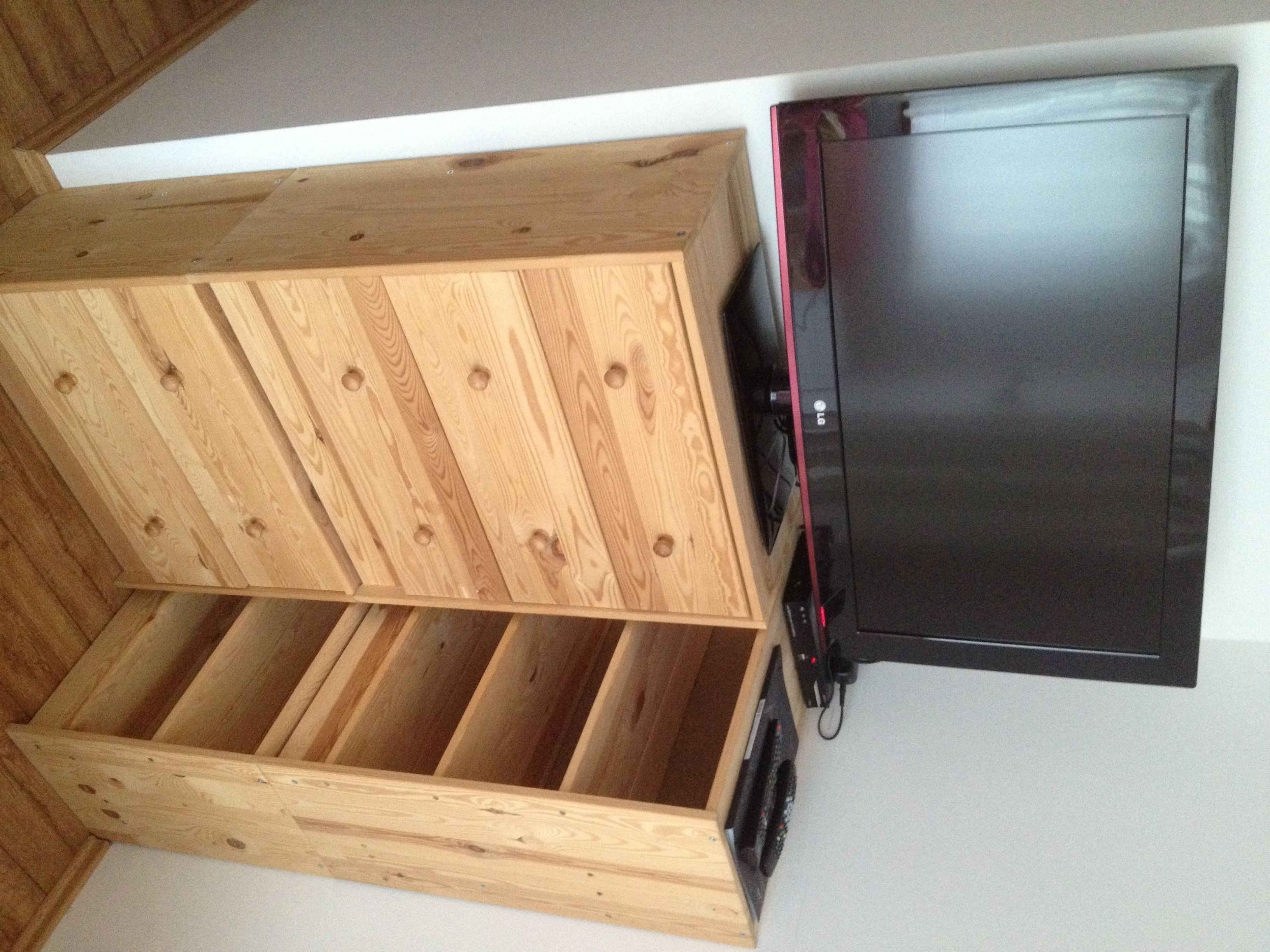Un mueble de madera con varios compartimentos y un refrigerador negro.