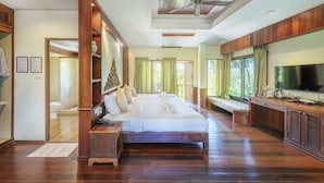 A spacious bedroom with a large bed, wooden headboard, a television, and a desk area. - Vana Varin Resort Hua Hin (Hua Hin)
