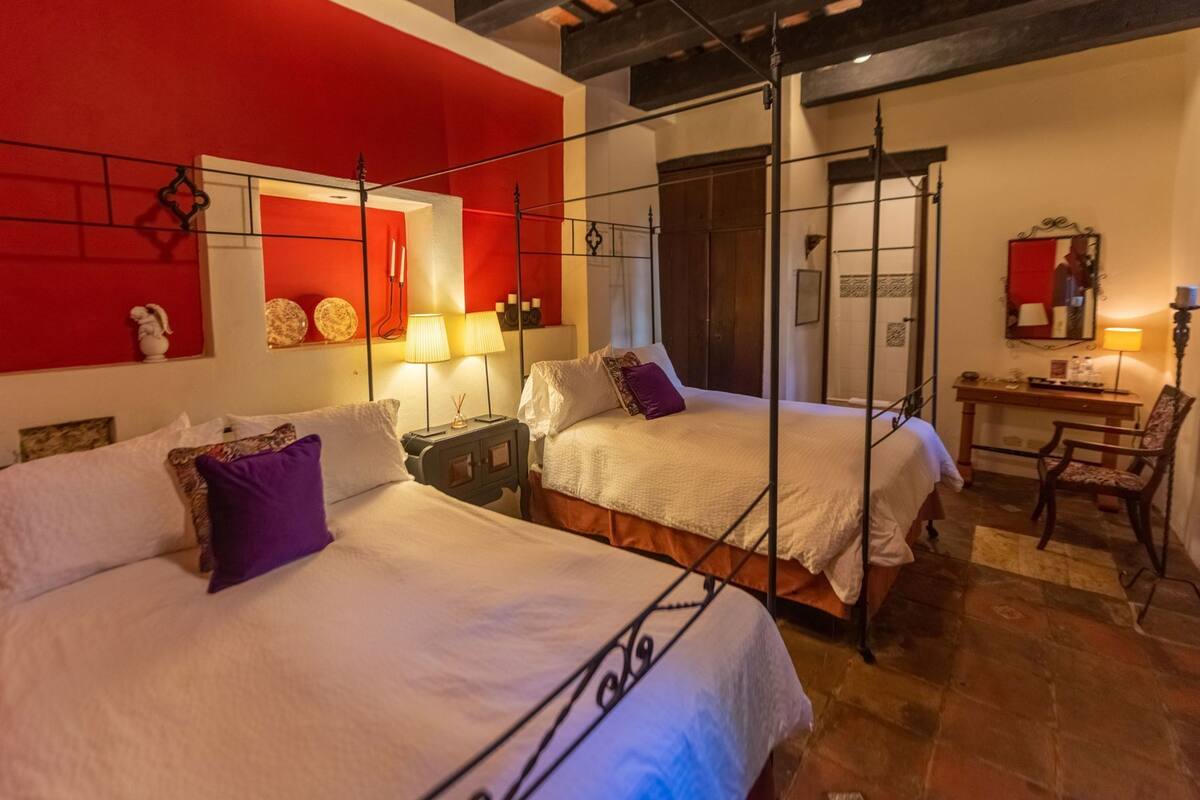 A room with two beds, a desk, and a chair.