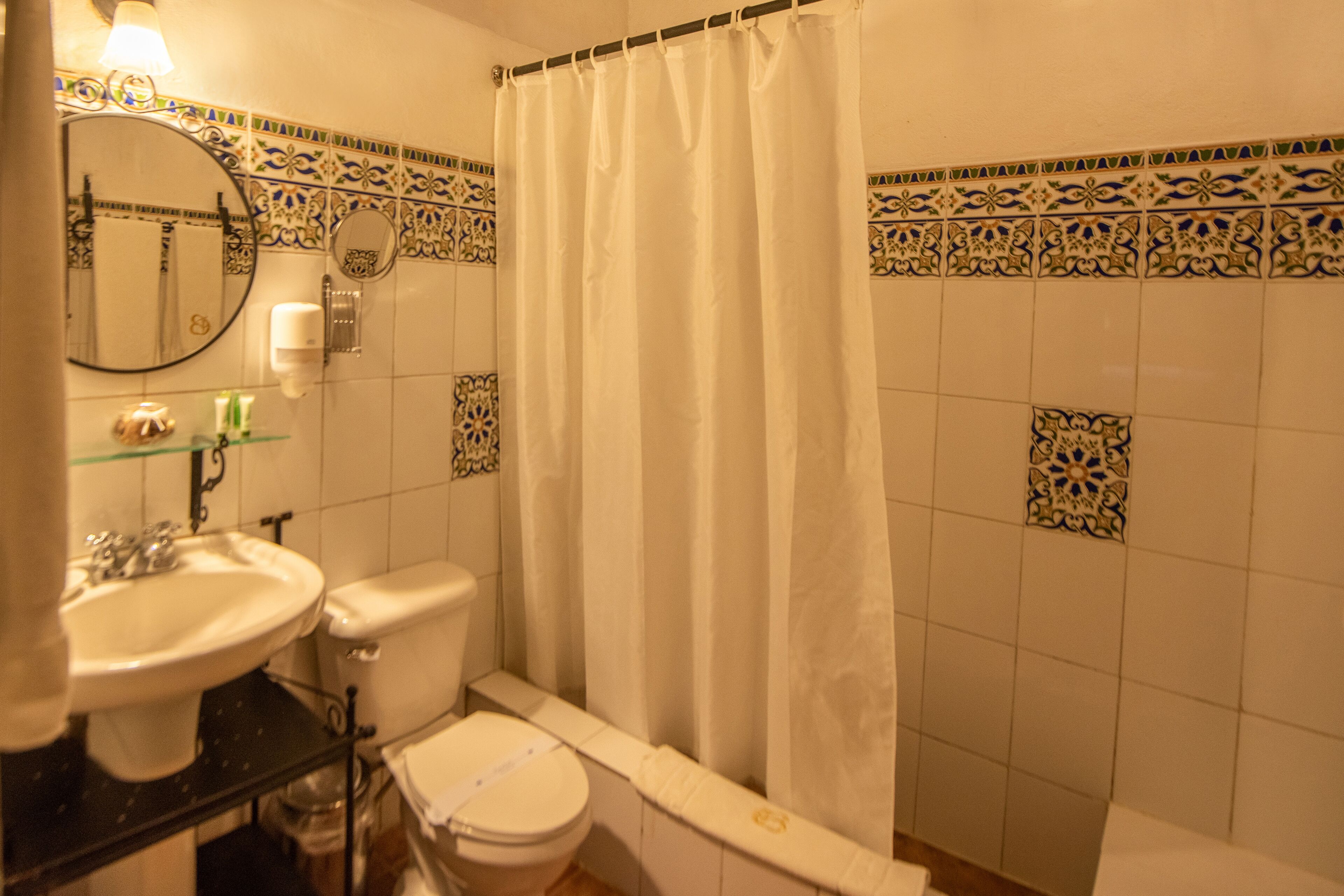 A bathroom with a sink, toilet, and shower curtain.