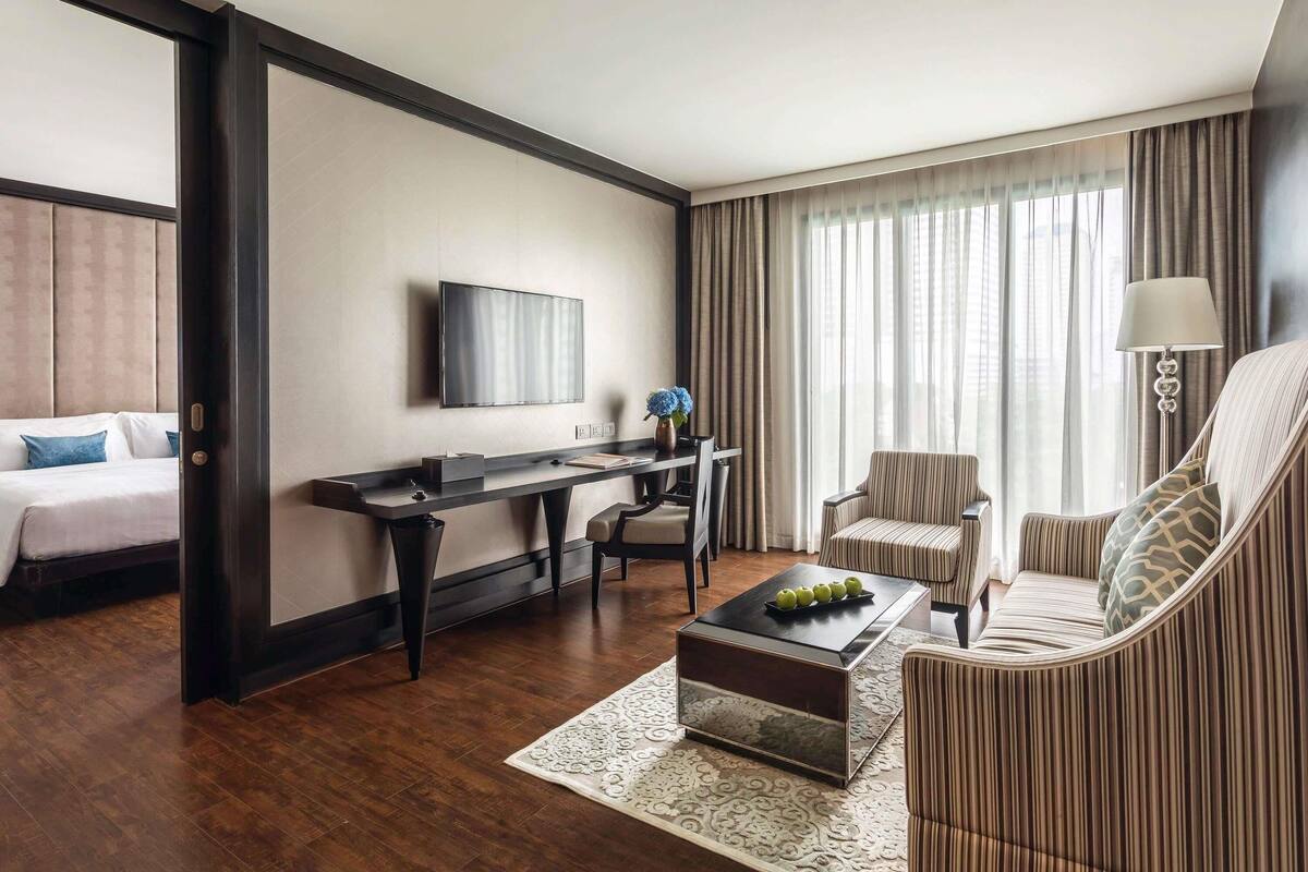 Une chambre d’hôtel comprenant un lit, un bureau, une télévision, une table basse et un canapé.