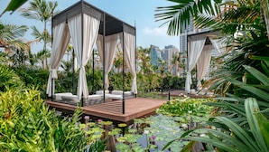 A serene garden with a gazebo, lush greenery, and a pond with lily pads. - Mövenpick Hotel Sukhumvit 15 Bangkok (Bangkok)