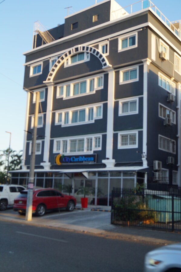 A multi-story hotel with a prominent "City Caribbean" sign, featuring a modern architectural design with a balcony on the upper floor. - City Caribbean Hotel Boutique (Santo Domingo)