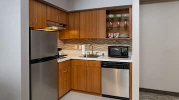 A modern kitchen with wooden cabinets, stainless steel appliances, and a microwave.