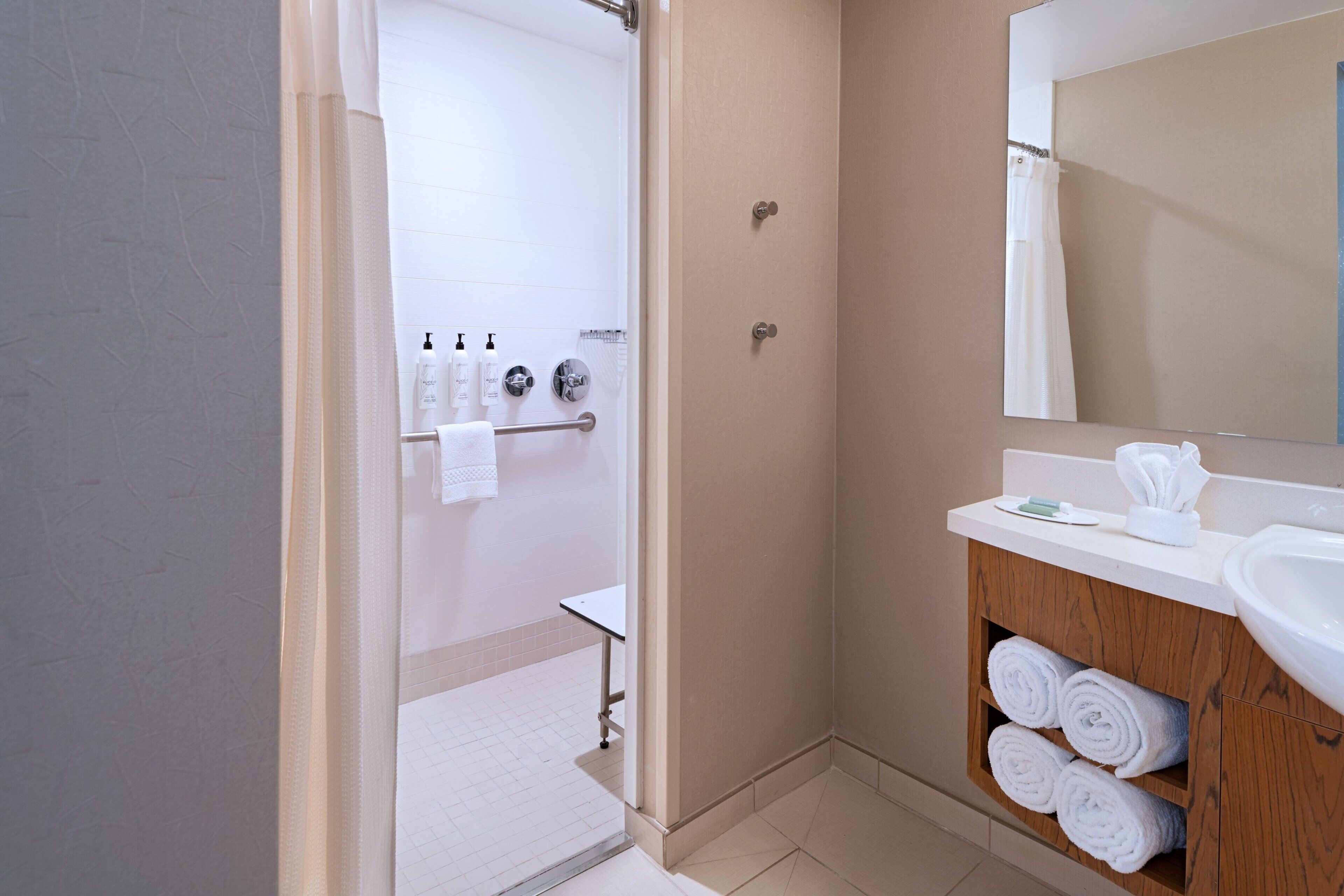 Une salle de bain moderne avec une douche, un lavabo et un miroir.