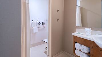 Une salle de bain moderne avec une douche, un lavabo et un miroir.