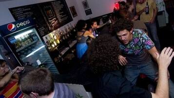 A crowded bar area with a Pepsi refrigerator and various people.