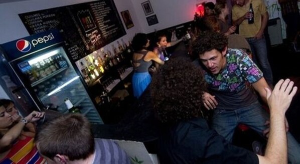 A crowded bar area with a Pepsi refrigerator and various people. - Art Factory San Telmo (Buenos Aires)