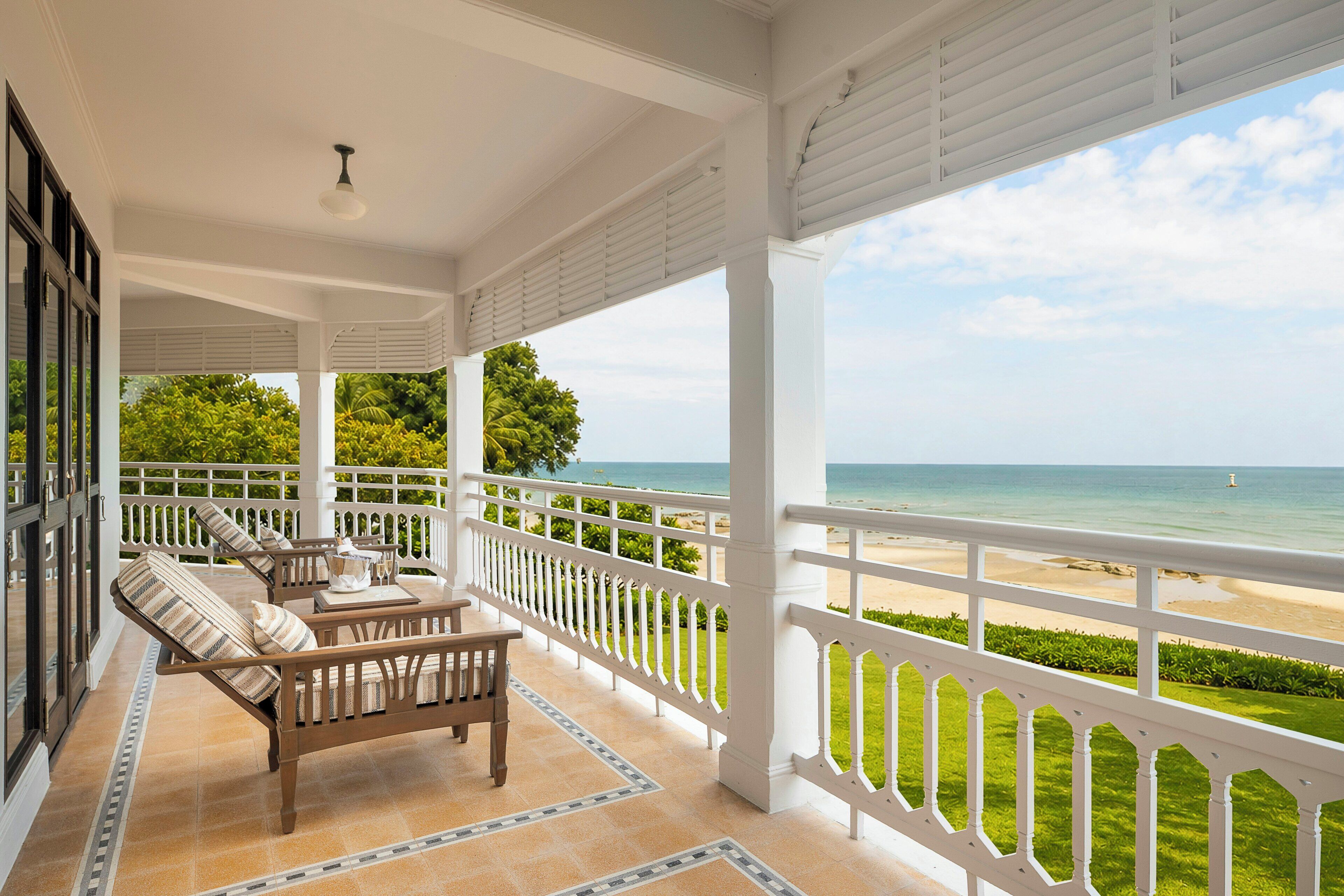A covered outdoor seating area with a view of the beach.