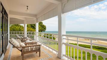 A covered outdoor seating area with a view of the beach.