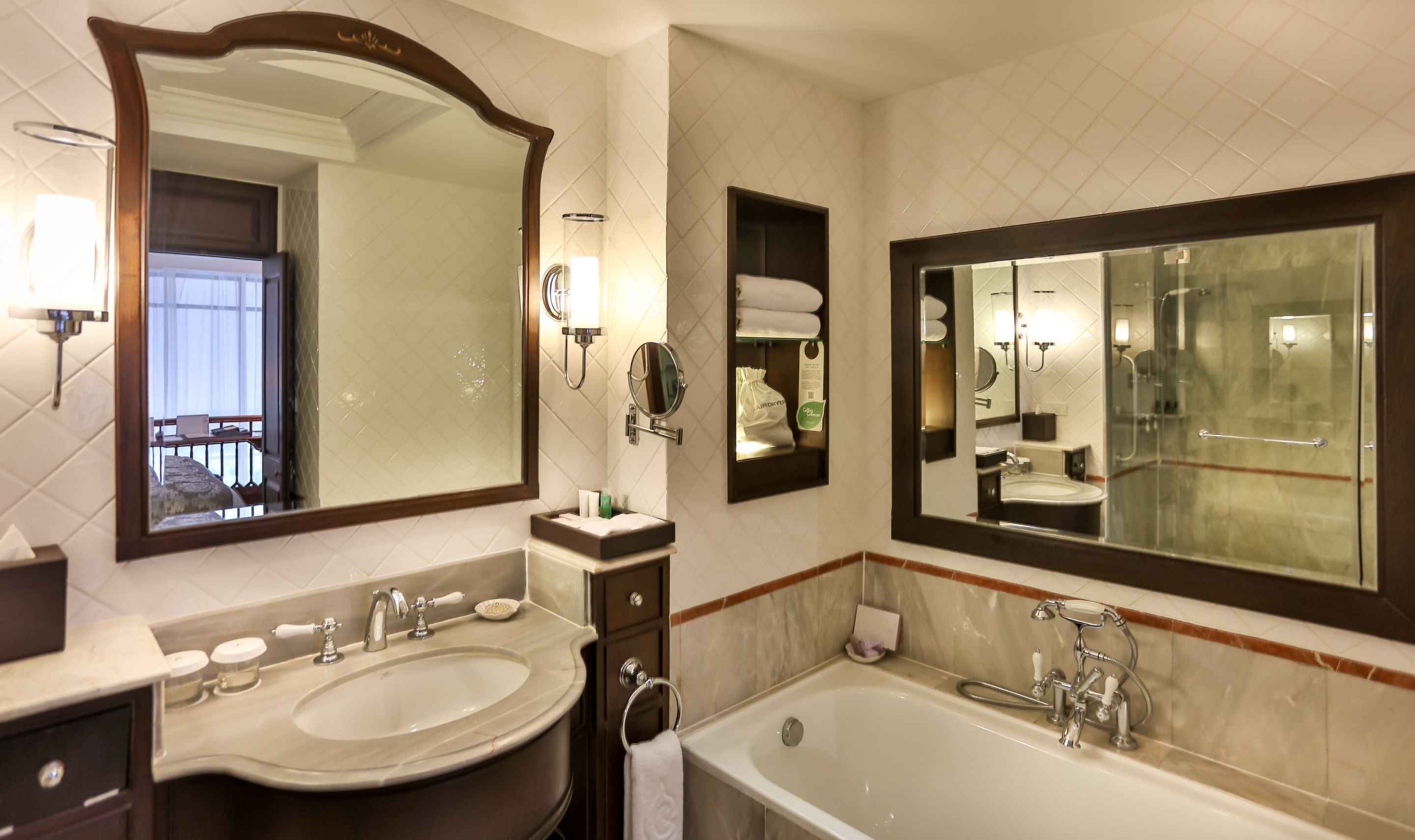 Un bagno con uno specchio grande, un lavandino, una vasca e un mobile con specchio.