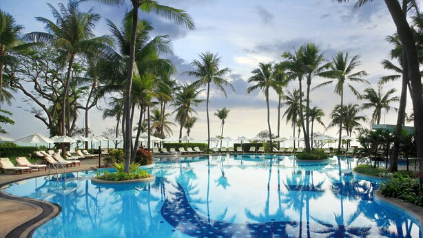 A large swimming pool surrounded by palm trees and sun loungers. - Centara Grand Beach Resort Hua Hin (Hua Hin)