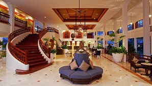 A spacious lobby with a grand staircase, a seating area, and large windows offering views of the outdoors. - Centara Grand Beach Resort Hua Hin (Hua Hin)