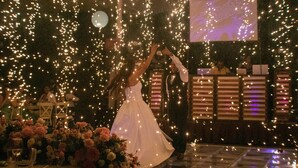 Une cérémonie de mariage avec une mariée en robe blanche, entourée d’invités et d’une cabine de DJ.