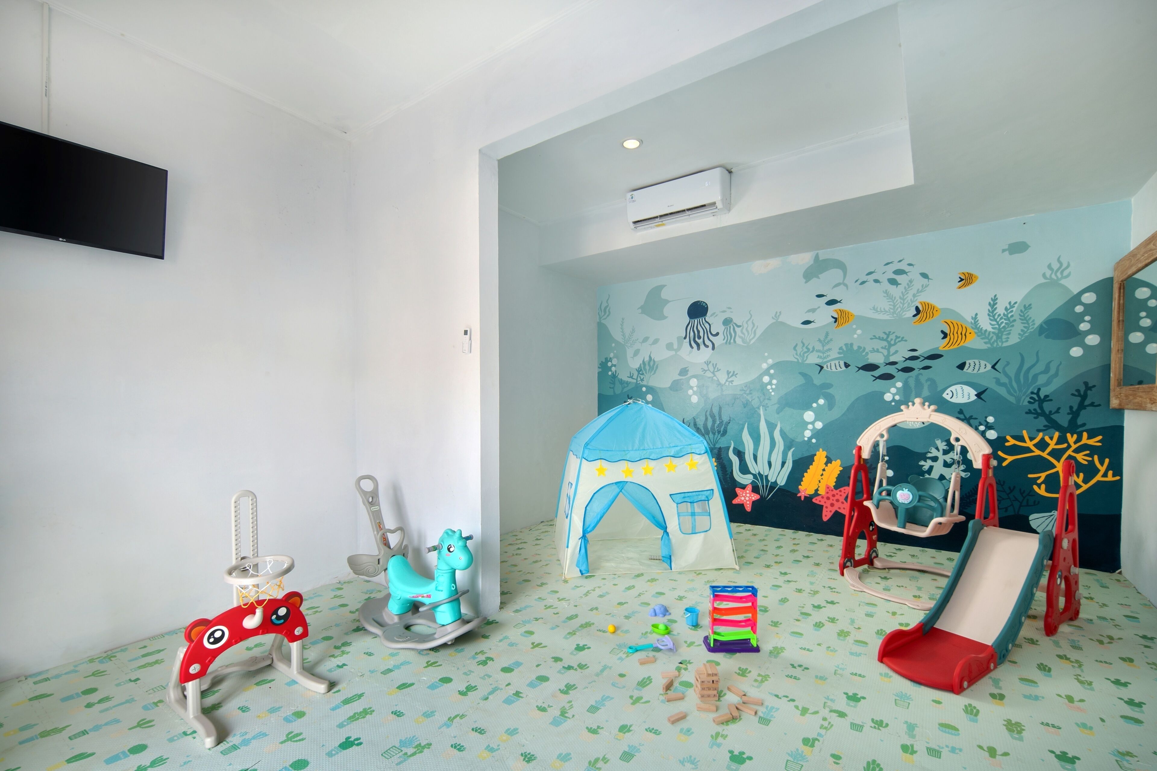 A child's playroom with a tent, rocking horse, and slide.