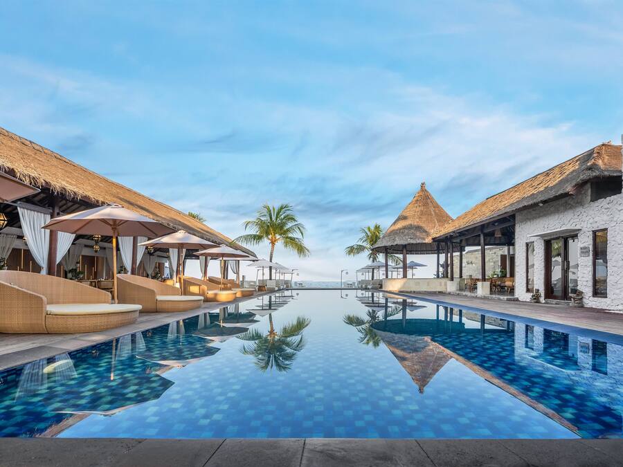 Una piscina al aire libre, sombrillas, tumbonas