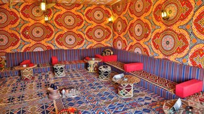 Una habitación con paredes decoradas, suelo estampado y asientos a rayas.