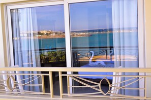 Un balcón con vista al mar y al paisaje urbano.