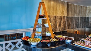 A buffet setup with a wooden ladder display and various food items. - Magic Beach Resort (Hurghada)