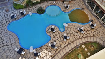 A pool area with multiple seating arrangements and a small water feature.