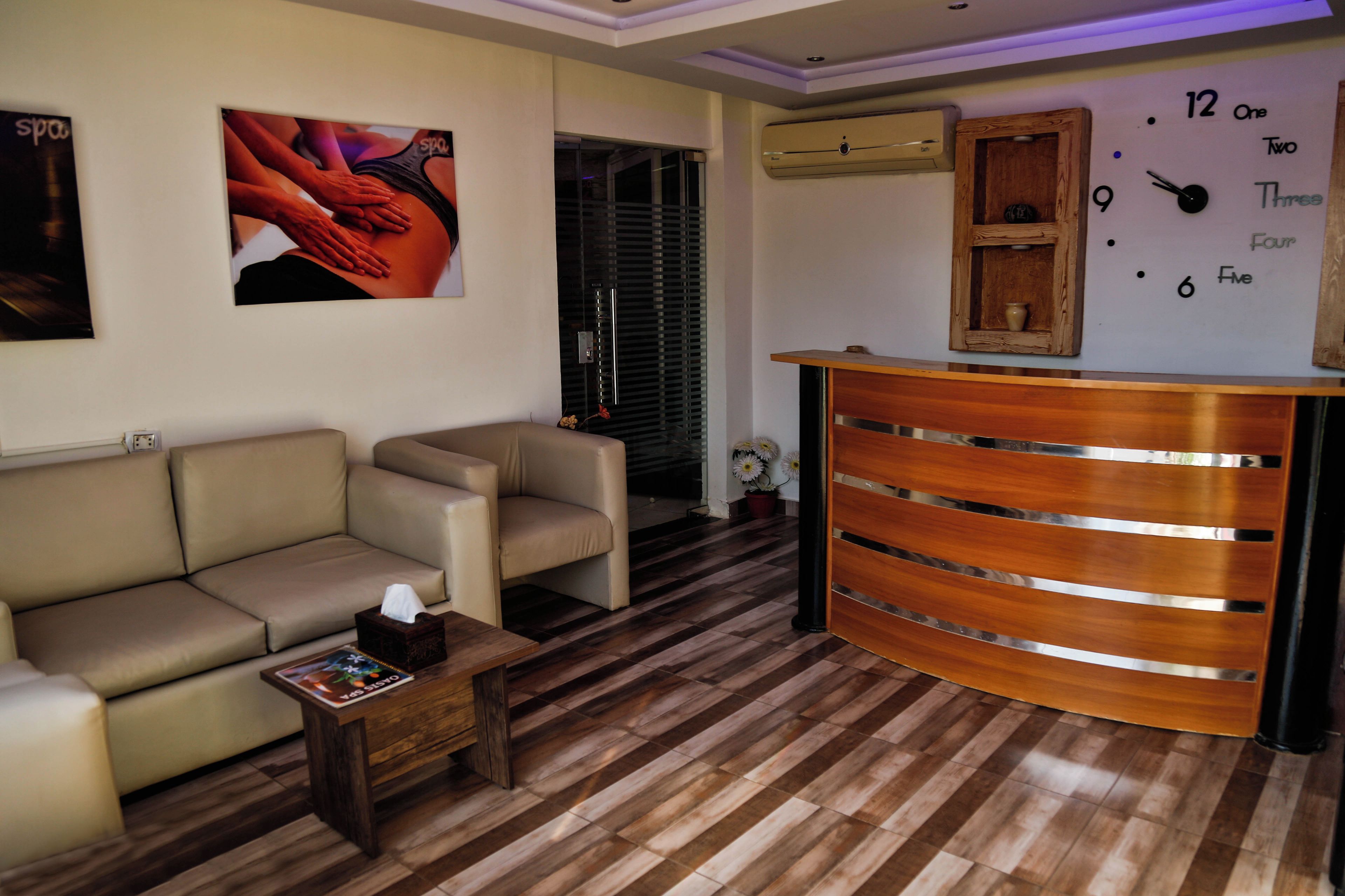 Una sala de estar con un sofá, una mesa de centro y un mostrador de recepción de madera.