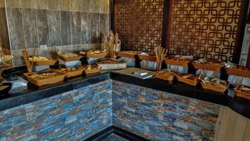 Uma área de buffet com diversos alimentos e cestas.