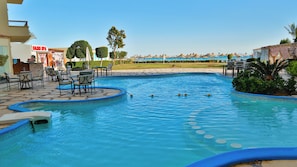 A swimming pool with lounge chairs and a spa sign in the background. - Magic Beach Resort (Hurghada)