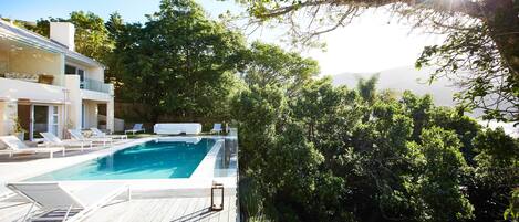 Outdoor pool, an infinity pool, pool umbrellas, sun loungers