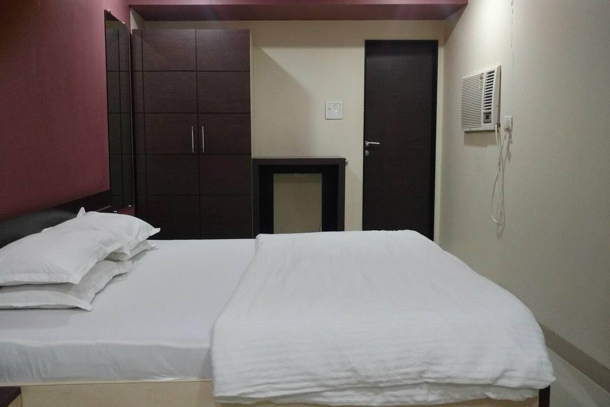 Una camera d'albergo con un letto, un armadio, una scrivania e una porta.