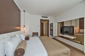 A modern hotel room with a large bed, a TV, and a seating area with a view of the city. - Istanbul Dora Hotel (Istanbul)