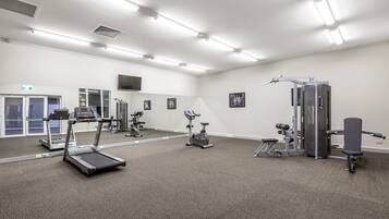 A gym with treadmills, an elliptical, and weight machines.
