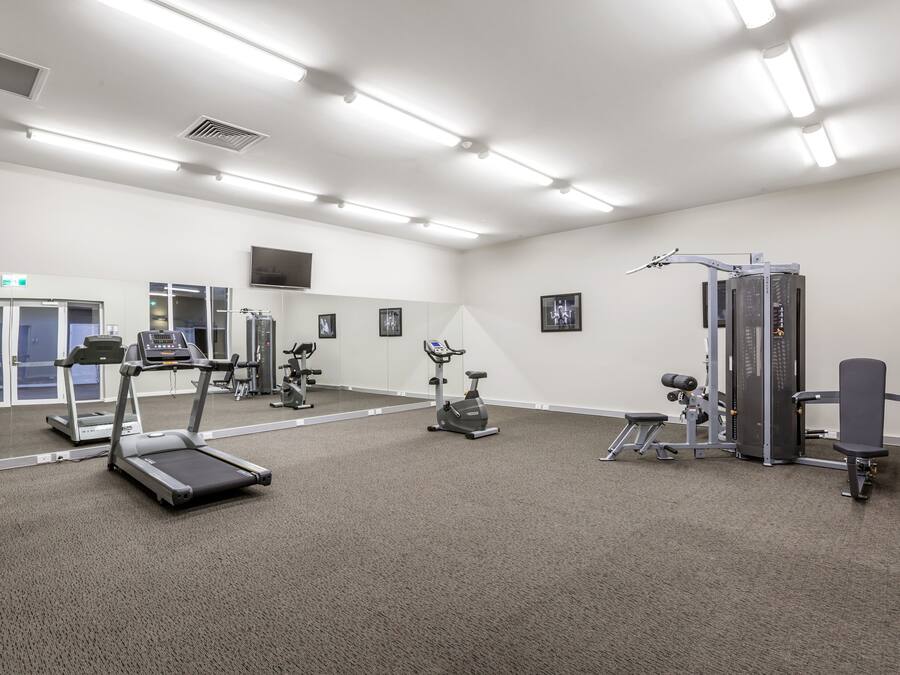 A gym with treadmills, an elliptical, and weight machines.