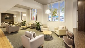 A modern living room with sofas, a coffee table, and large windows offering a view of the outside. - Quest Albury On Townsend (Albury)