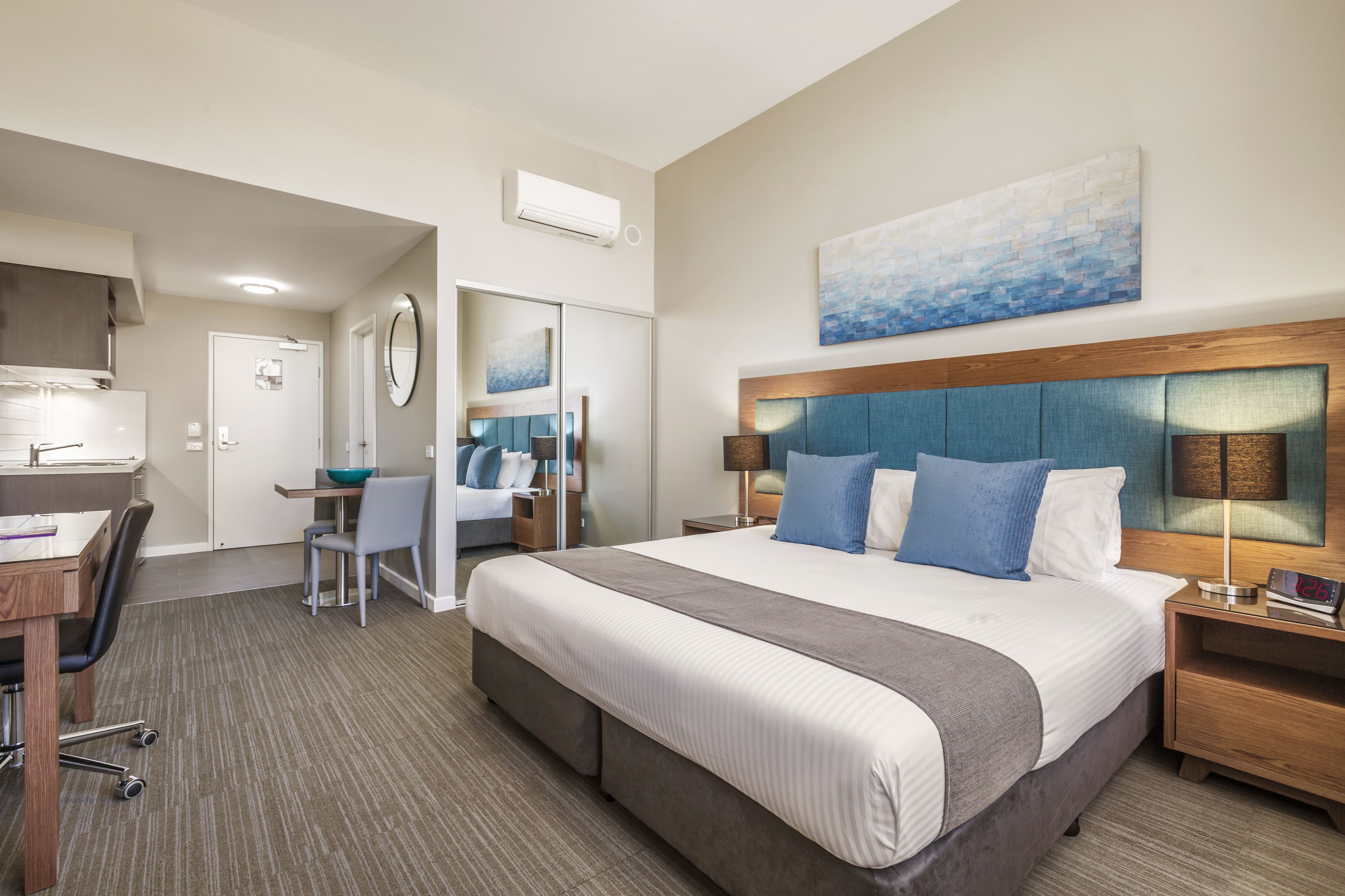 Une chambre d’hôtel avec un grand lit, un bureau, une chaise et une salle de bain.