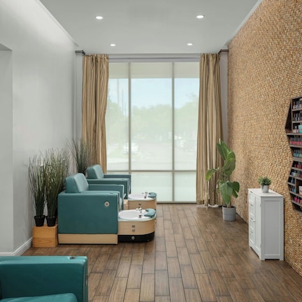 A modern room with a large window, a brick-patterned wall, and a small bookshelf.