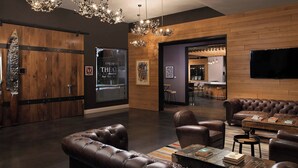 A modern interior with leather sofas, a wooden wall, and a bar area. - Epicurean Hotel, Autograph Collection (Tampa)