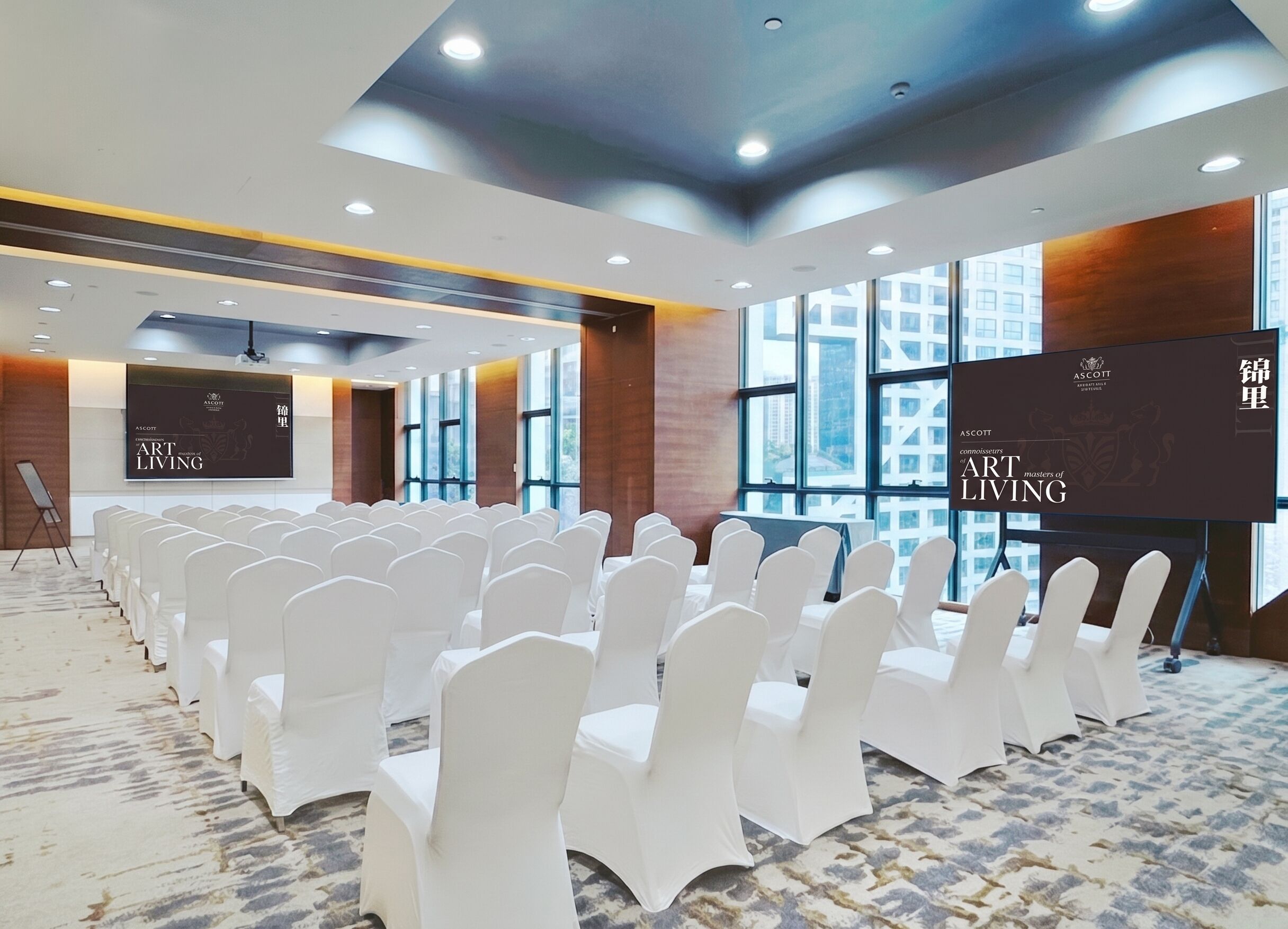 Une salle de conférence avec des rangées de chaises blanches, de grandes fenêtres et deux écrans de projection affichant le texte « ASCOTT ART LIVING ».